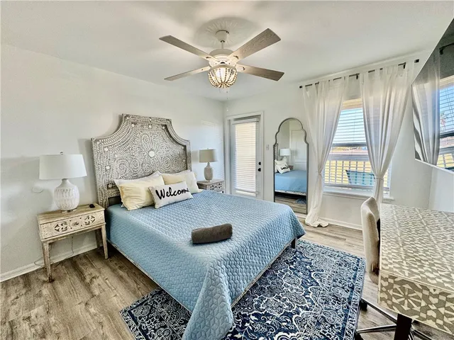 a spacious bedroom with a bed a window and dresser