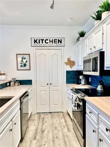 a kitchen with white cabinets and refrigerator