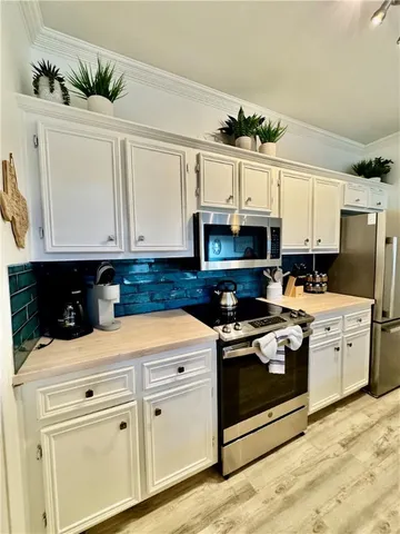 a kitchen with stainless steel appliances granite countertop a refrigerator stove a sink dishwasher and microwave oven