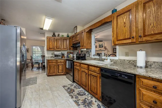 a kitchen with granite countertop stainless steel appliances and wooden cabinets