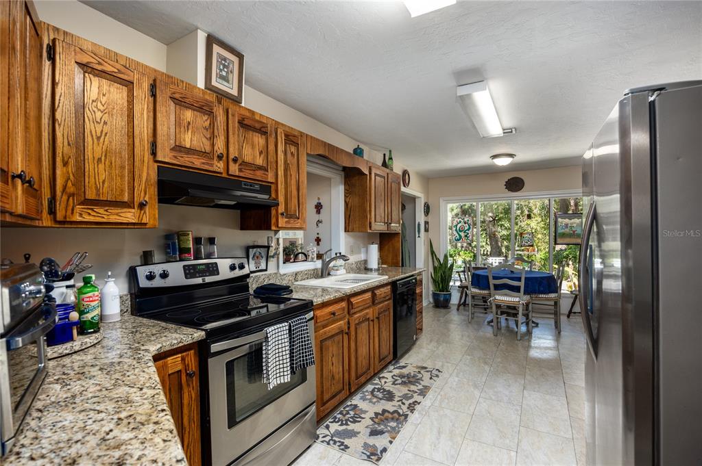 11440 Southwest Archer Road Gainesville, FL 32608 - Photo 21 of 44 a kitchen with stainless steel appliances granite countertop a stove a sink and a refrigerator