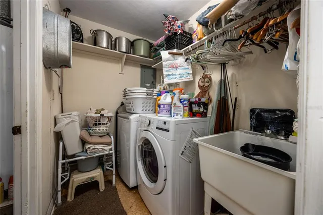 a utility room with dryer washer and a view of living room