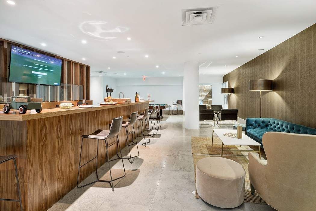429 Kent Avenue, Unit 503 Brooklyn, NY 11249 - Photo 12 of 14 a living room with furniture a wooden floor and kitchen view