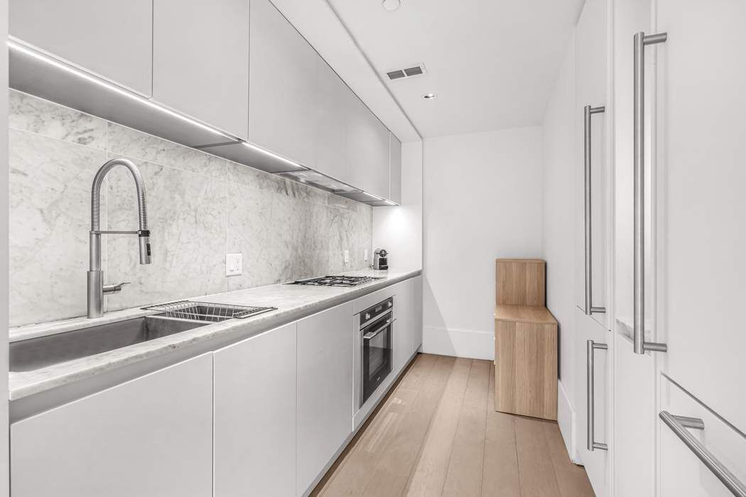429 Kent Avenue, Unit 503 Brooklyn, NY 11249 - Photo 4 of 14 a large white kitchen with sink and washing machine