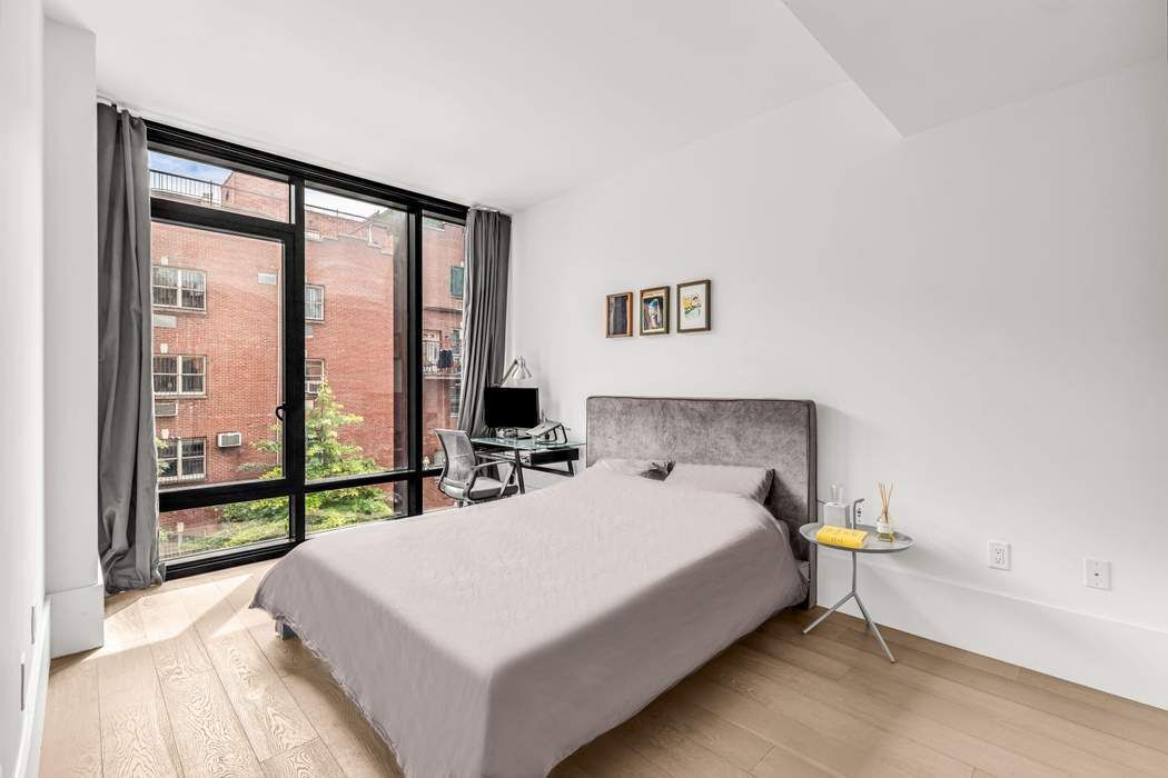 429 Kent Avenue, Unit 503 Brooklyn, NY 11249 - Photo 6 of 14 a bedroom with a bed and a large window