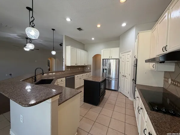 a kitchen with stainless steel appliances kitchen island granite countertop a sink and cabinets