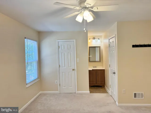 a view of a livingroom with a chandelier fan and a window