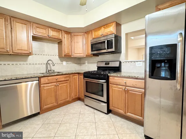 a kitchen with granite countertop a stove top oven microwave and cabinets