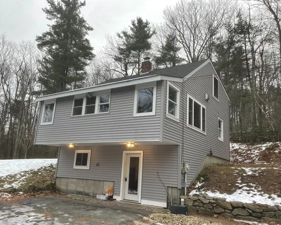 a front view of a house with a tree