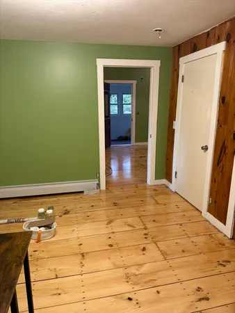 a view of a room with wooden floor and bathroom