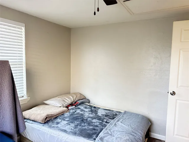 a bedroom with a bed and a window