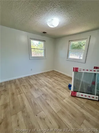 a view of a room with wooden floor and white walls
