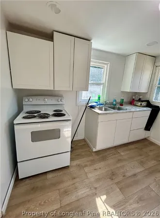 a kitchen with stainless steel appliances a stove a sink and white cabinets