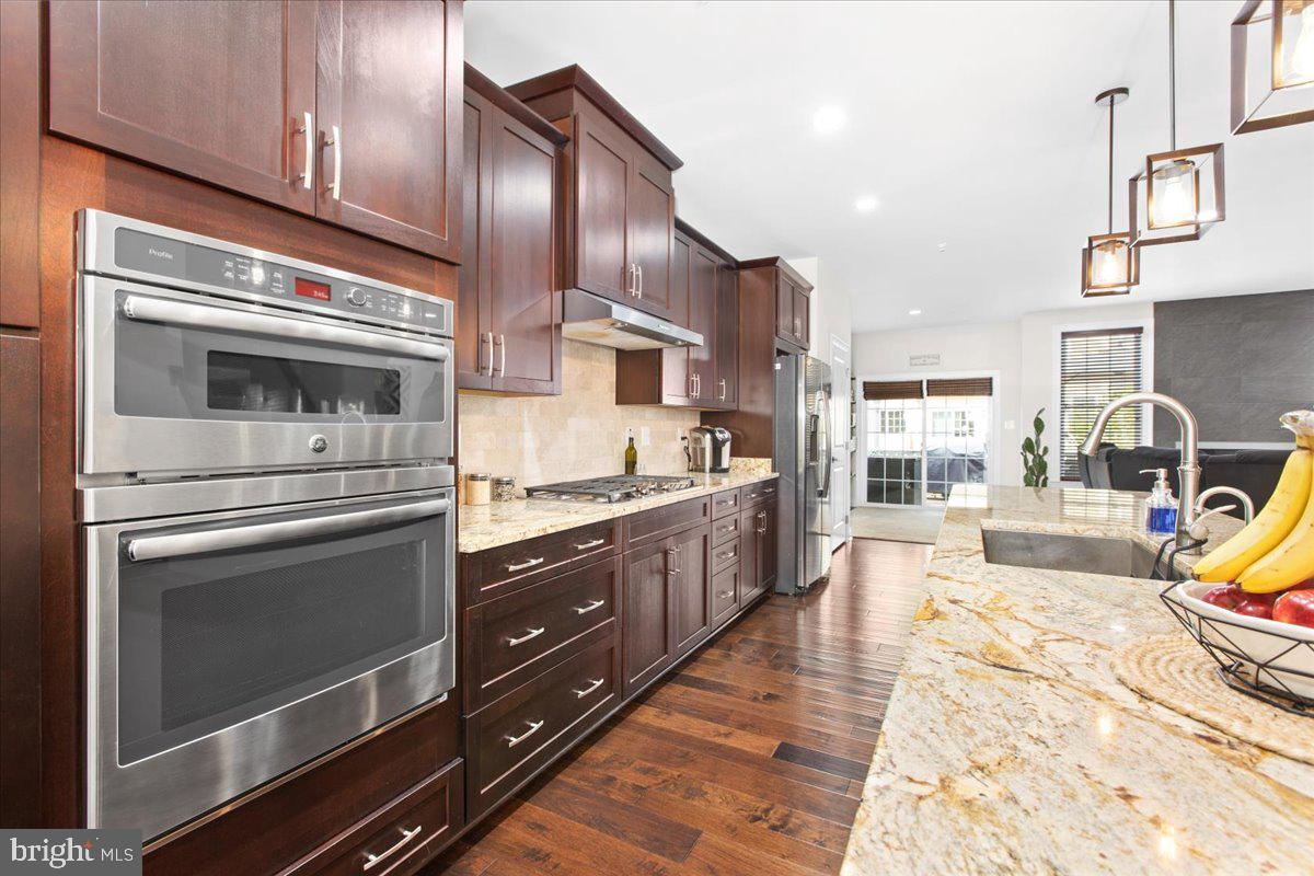 2617 Maple Rock Road Hanover, MD 21076 - Photo 15 of 53 a kitchen with stainless steel appliances kitchen island granite countertop a stove a sink and a refrigerator