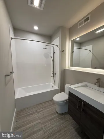 a bathroom with a bathtub shower sink vanity and toilet