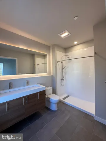 a bathroom with a sink a toilet and shower