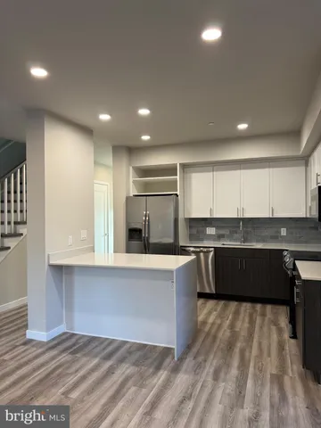 a large kitchen with kitchen island a sink counter top space and cabinets
