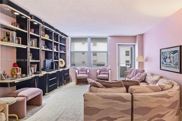 a living room with furniture and a book shelf