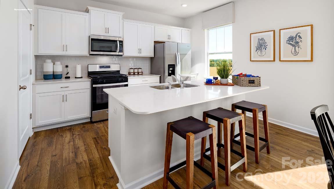 602 Dazzle Loop Newton, NC 28658 - Photo 6 of 29 a kitchen with stainless steel appliances a sink a stove a refrigerator cabinets and a dining table