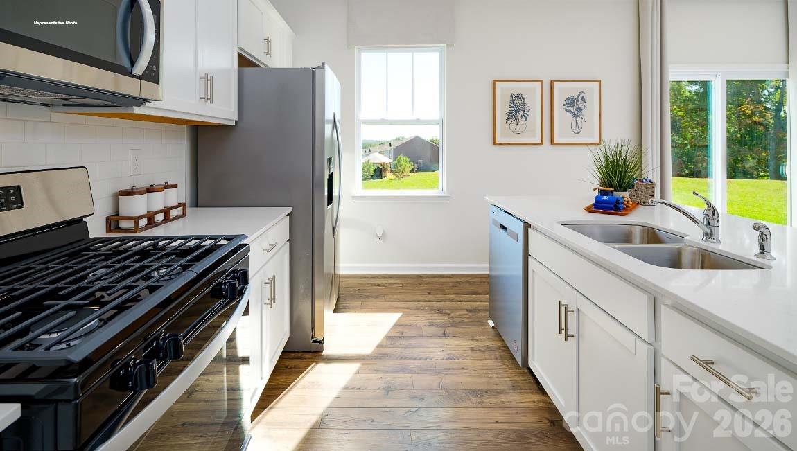 602 Dazzle Loop Newton, NC 28658 - Photo 7 of 29 a kitchen with stainless steel appliances a stove a sink and a refrigerator