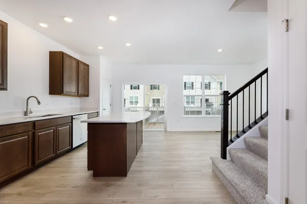 a large kitchen with stainless steel appliances granite countertop a large counter top and a wooden floors