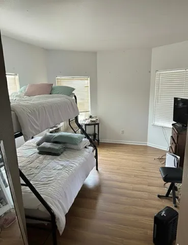 a bedroom with a bed and wooden floor