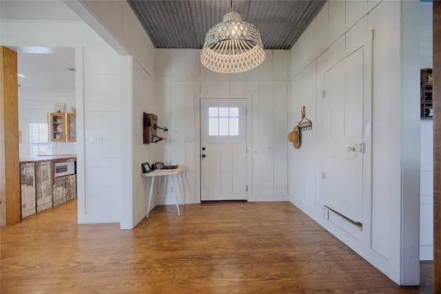 a living room with furniture kitchen view and a wooden floor