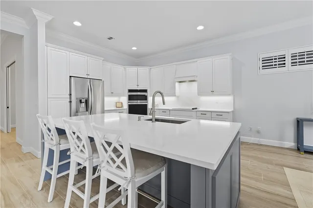a kitchen with stainless steel appliances a table and chairs in it