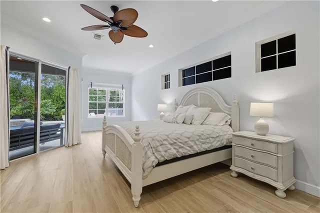 a bedroom with a large bed and a chandelier fan
