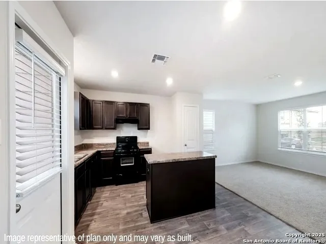 a kitchen with stainless steel appliances kitchen island sink refrigerator and stove