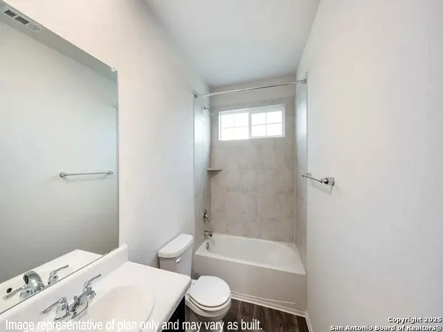 a white toilet and tub next to a bathroom sink