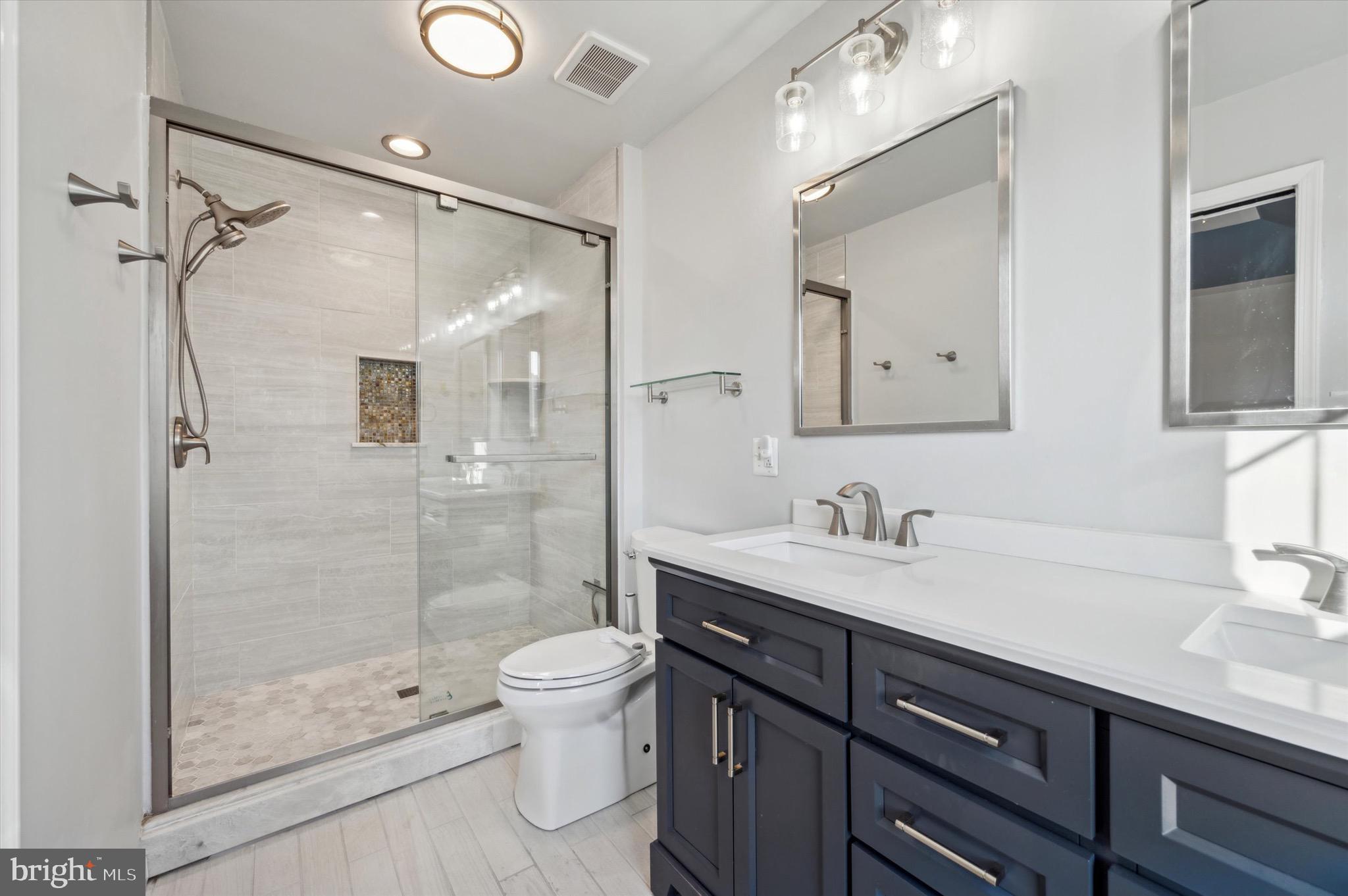 212 Cobblestone Drive Ardmore, PA 19003 - Photo 12 of 15 a bathroom with a granite countertop sink a toilet a mirror and shower