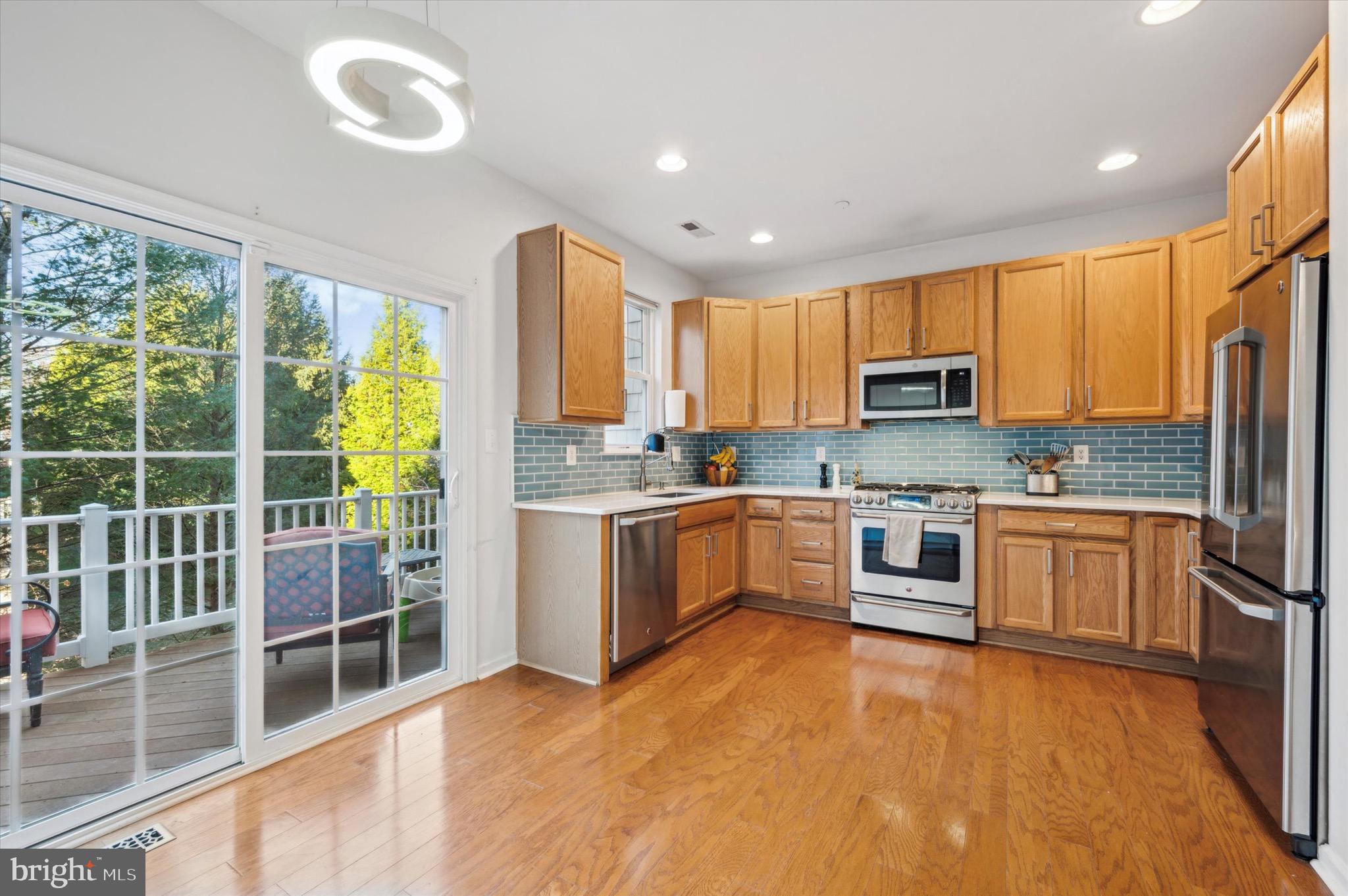 212 Cobblestone Drive Ardmore, PA 19003 - Photo 4 of 15 a kitchen with kitchen island granite countertop a stove a sink a refrigerator a window and cabinets