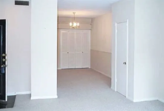 an empty room with kitchen view