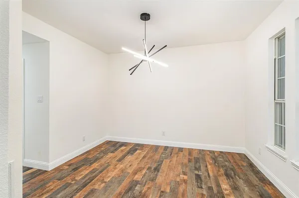 a view of a room with wooden floor and a ceiling fan