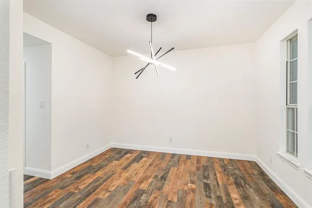 a view of a room with wooden floor and a ceiling fan