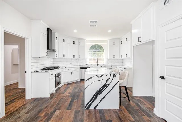 a kitchen with white cabinets and stainless steel appliances