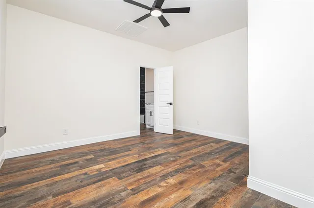 a view of a room with wooden floor and a ceiling fan