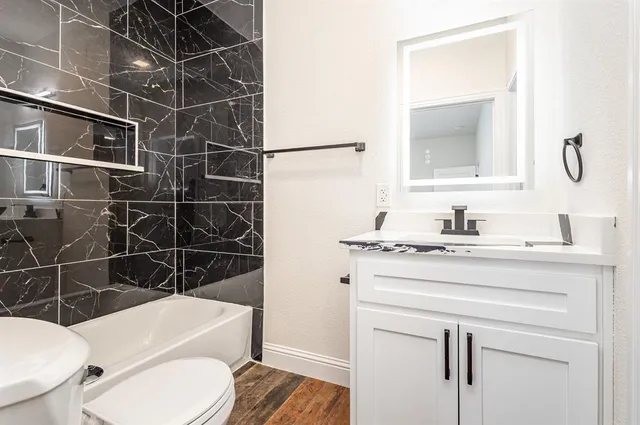 a bathroom with a toilet a sink and a mirror