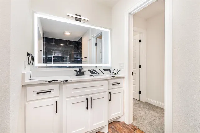 a bathroom with a sink vanity and mirror
