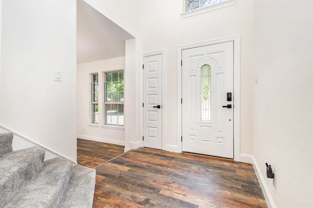 an empty room with window and wooden floor