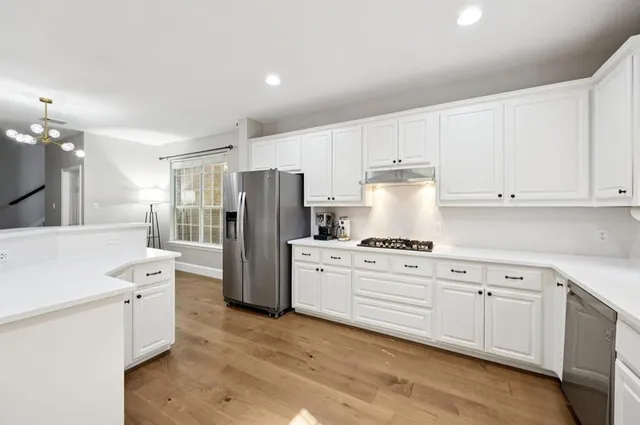 a kitchen with white cabinets and white stainless steel appliances