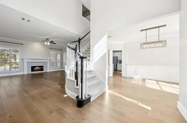 a view of a livingroom with fireplace a ceiling fan a fireplace and windows