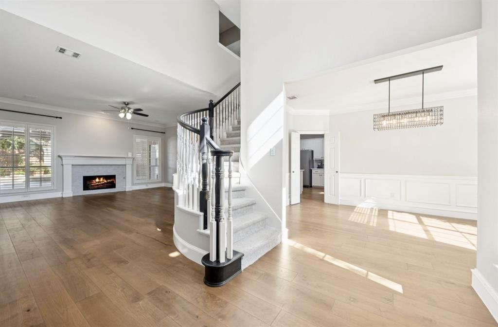 7913 Morningdew Drive Plano, TX 75025 - Photo 14 of 40 a view of a livingroom with fireplace a ceiling fan a fireplace and windows
