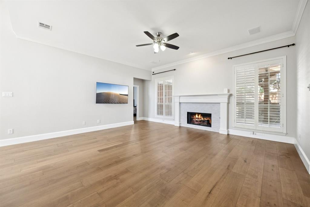 7913 Morningdew Drive Plano, TX 75025 - Photo 16 of 40 a view of an empty room with wooden floor fireplace and a window