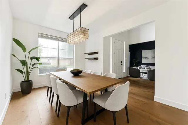 a view of a dining room and livingroom with furniture wooden floor a chandelier