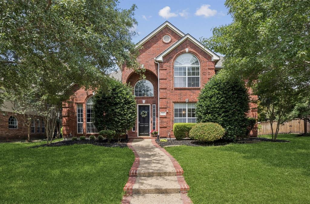 7913 Morningdew Drive Plano, TX 75025 - Photo 2 of 40 a front view of a house with a garden