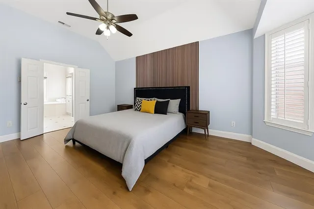 a bedroom with a bed and wooden floor
