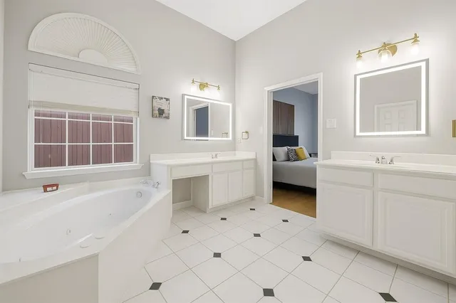 a en suite bathroom with a double vanity sink mirror and bathtub