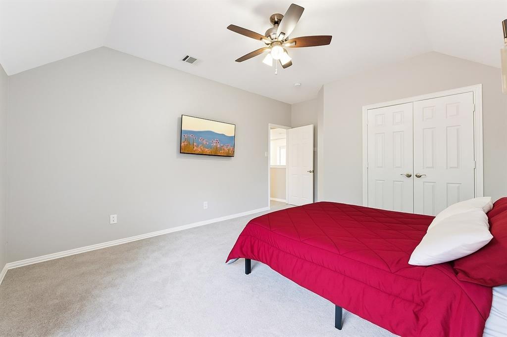 7913 Morningdew Drive Plano, TX 75025 - Photo 30 of 40 a bedroom with a large bed and a chandelier